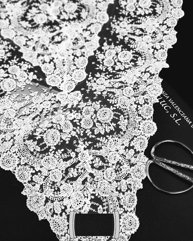 Detalle de encaje blanco de dibujo floral sobre fondo negro