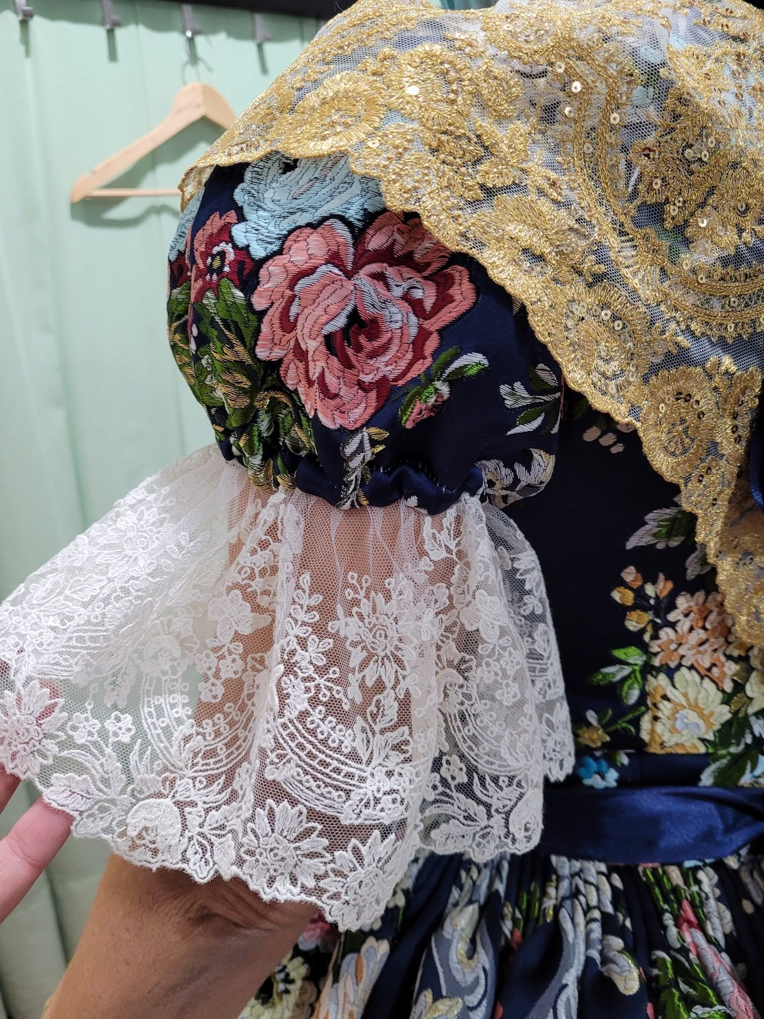Detalle de puño de encaje blanco sobre manga floral