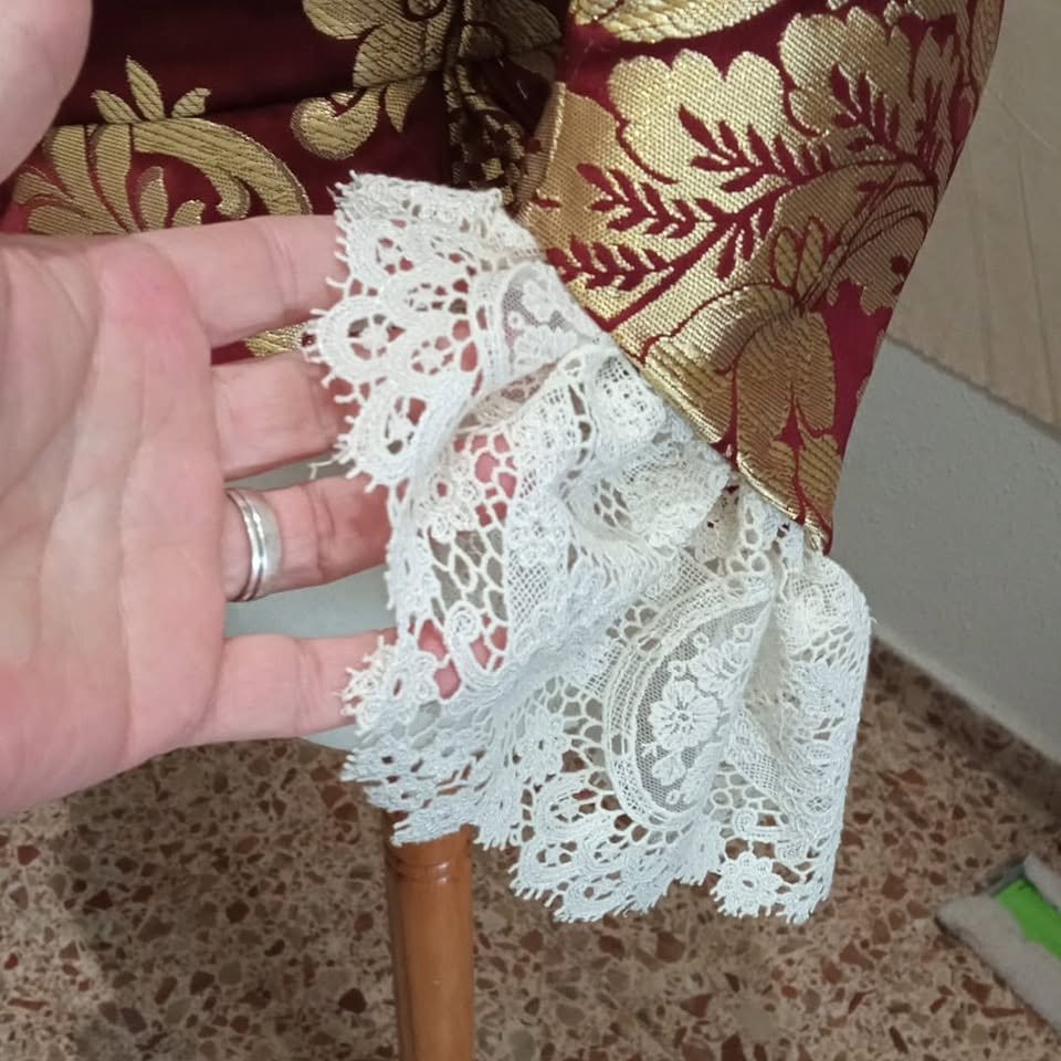 Mano sosteniendo una puntilla blanca de dibujo floral