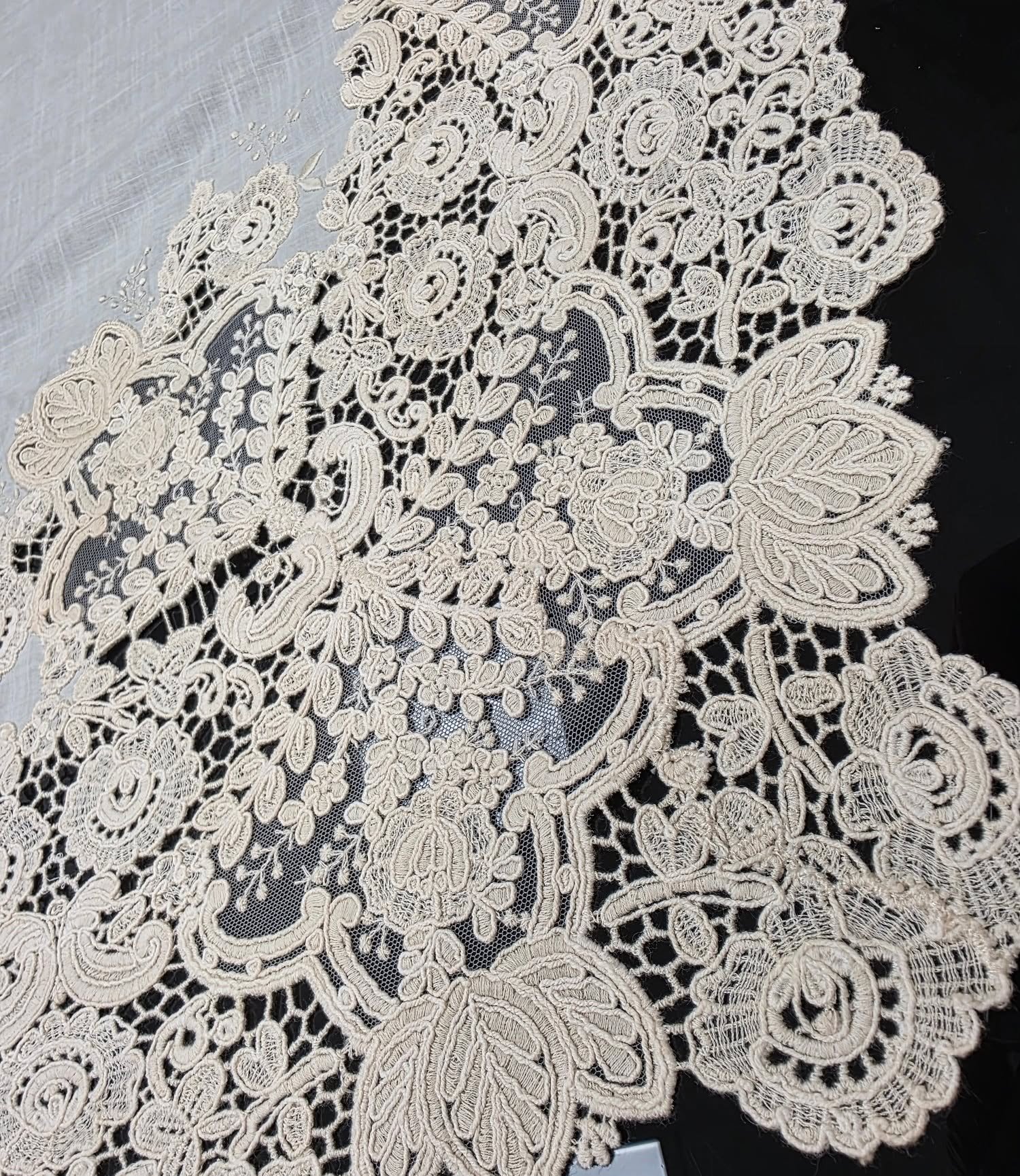 Primer plano de encaje floral blanco sobre fondo oscuro