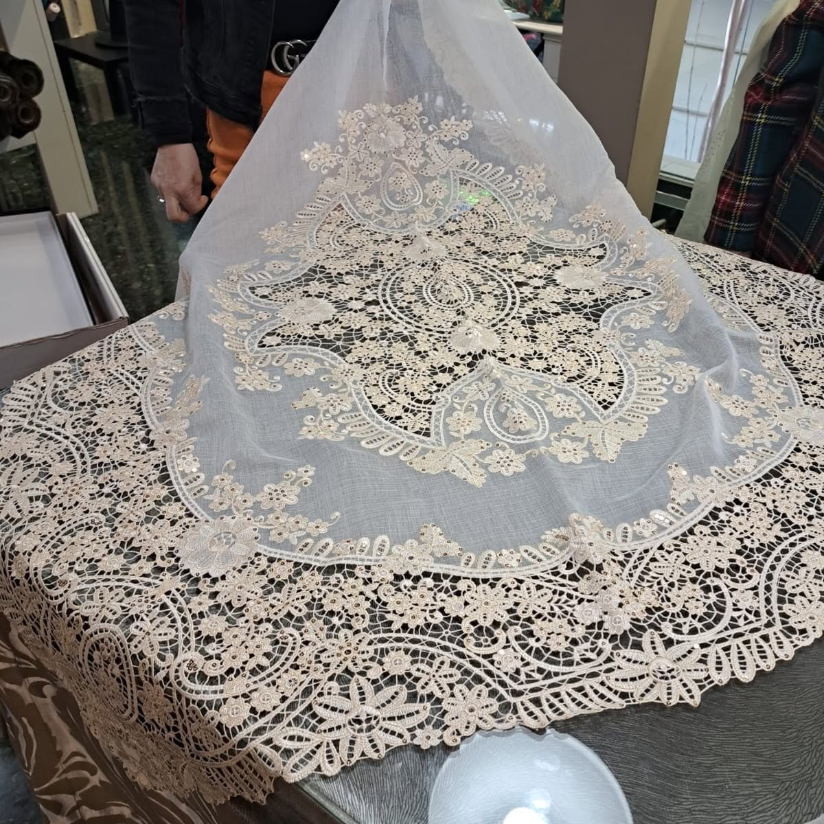 Mantilla triangular clara presentada sobre una mesa de trabajo