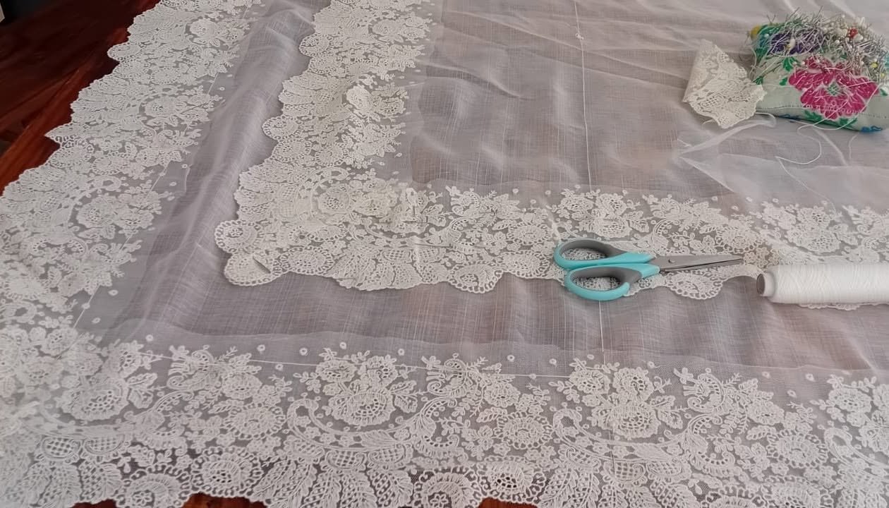 Tijeras junto a una puntilla blanca colocada sobre tul rosado