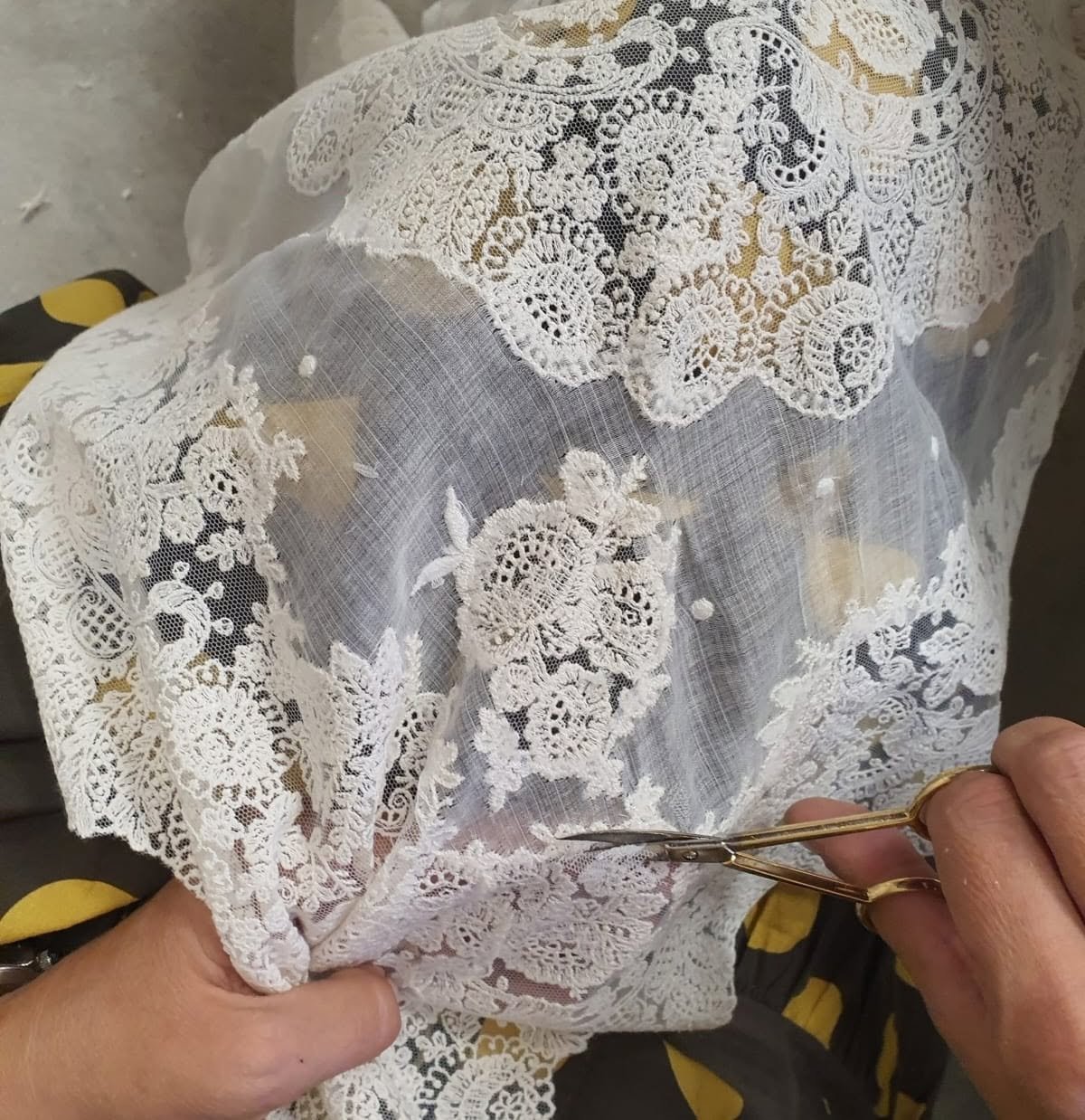 Manos realizando el acabado de una pieza de encaje